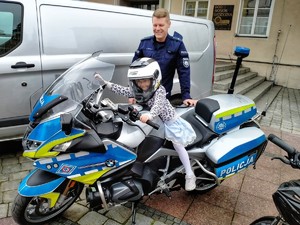 Zdjęcie przedstawia dziecko na motocyklu policyjnym.