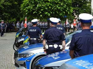 policjanci ruchu drogowego stoją przy radiowozach