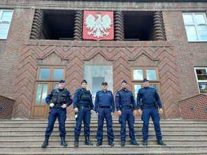 5 policjantów stoi na schodach