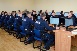 policjanci rozwiązują test wiedzy na komputerach