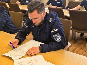 Zdjęcie przedstawia policjanta piszącego test.