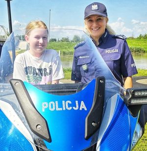 policjantka obok dziecka na motocyklu