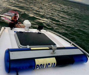 akcja ratunkowa, mężczyzna na desce w wodzie i policyjna łódź