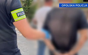 policjant prowadzi zatrzymanego