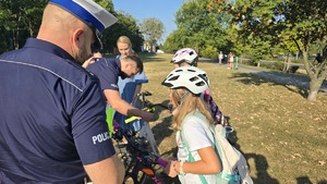 policjanci rozdają odblaski i rozmawiają z dziećmi