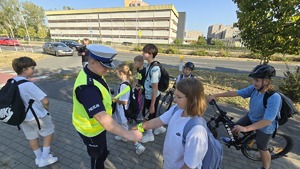 policjanci rozdają odblaski i rozmawiają z dziećmi