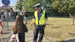 policjanci rozdają odblaski i rozmawiają z dziećmi