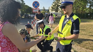 policjanci rozdają odblaski i rozmawiają z dziećmi