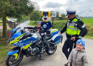 policjant i dzieci obok motocykla policyjnego