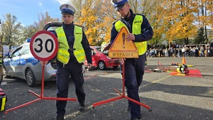 policjanci na pokazie niosą tymczasowe znaki drogowe