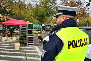 Zdjęcie przedstawia policjanta na cmentarzu.