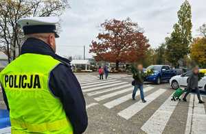 Zdjęcie przedstawia policjanta na cmentarzu.