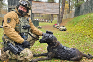 Zdjęcie przedstawia psa z policjantem.