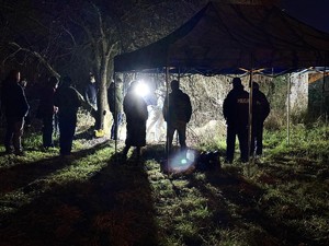 Zdjęcie przedstawia policjantów pracujących na miejscu przestępstwa.