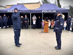 Zdjęcie przedstawia policjantów oddających sobie honor.