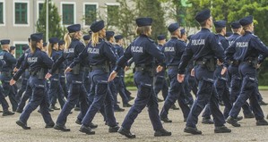 zdjęcie kolorowe: studenci kierunku Nauka o Policji maszerujący na terenie campusu