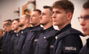 Zdjęcie przedstawia nowoprzyjętych policjantów, stojących w szeregu.