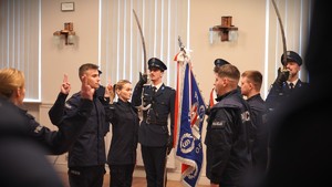 Zdjęcie przedstawia ślubujących policjantów, w tle sztandar.