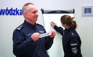 Zdjęcie przedstawia policjanta, z kartą w ręce.