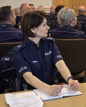 policjantka podczas szkolenia, na stole przed nią materiały dydaktyczne