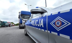 Zdjęcie przedstawia radiowóz, na drugim tle ciężarówka.