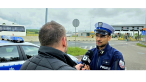 Zdjęcie przedstawia policjanta rozmawiającego z dziennikarzem.