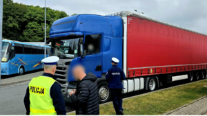 Zdjęcie przedstawia policjantów kontrolujących ciężarówkę