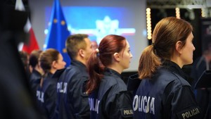 Zdjęcie przedstawia policjantów, stojących tyłem.