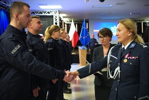 Policjantka podaje rękę policjantowi.