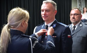 Policjantka wręcza medal policjantowi.