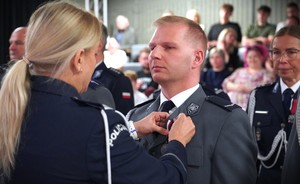Policjantka wręcza medal policjantowi.