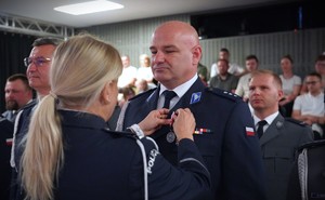 Policjantka wręcza medal policjantowi.