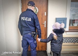 zdjęcie kolorowe: policjant odprowadzający dziecko do domu