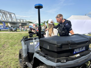 policjanci na pikniku ekologicznym prezentują sprzęt i rozmawiają o bezpieczeństwie