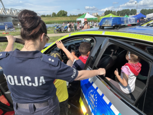 policjanci na pikniku ekologicznym prezentują sprzęt i rozmawiają o bezpieczeństwie