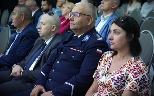 Kobieta i mężczyzna w mundurze słuchają wykładu.