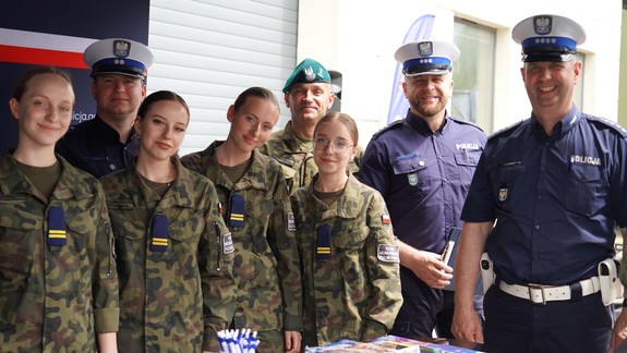 Policjanci ruchu drogowego i dziewczyny w wojskowym mundurze.