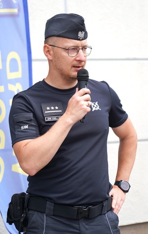 Strażnik więzienny przemawia do mikrofonu.