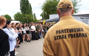 Strażak, w tle grupa ludzi.