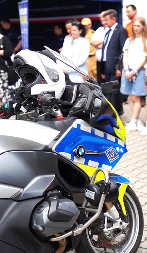 Motocykl policyjny, w tle grypa ludzi.