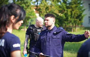 Policjant wskazuje ręką.