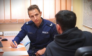 Policjant pilnuje petenta.