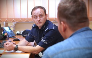 Policjant pilnuje petenta.