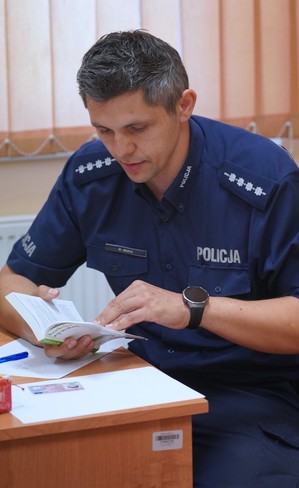 Policjant pilnuje petenta.