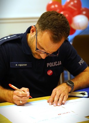 Policjant wypisuje kwestionariusz.