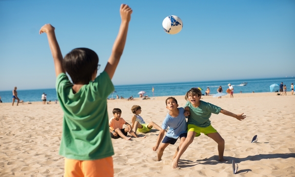 zdjęcie: dzieci grające w piłkę na plaży
