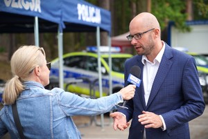 Zdjęcie: mężczyzna wypowiada się do mikrofonu.