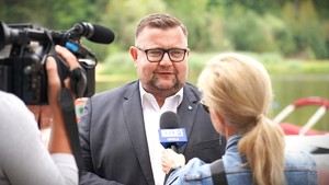 Zdjęcie: mężczyzna wypowiada się do kamery.