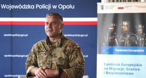 Zdjęcie: policjant na tle baneru.