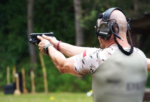 Zdjęcie policjant strzela w deszczu.